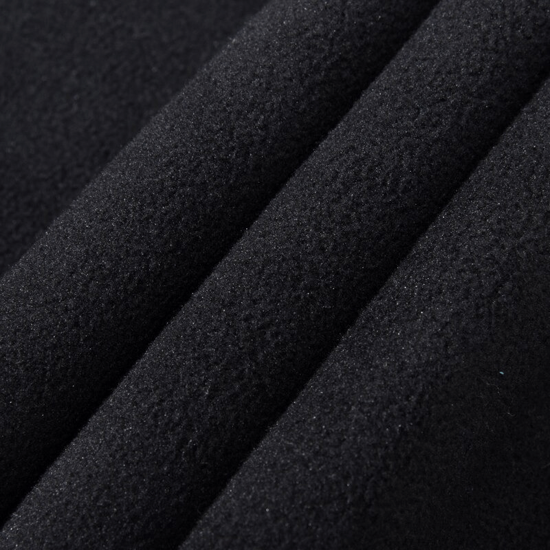 Close-up of black fleece fabric used in women's windproof waterproof pants, showing texture and durability for outdoor activities.